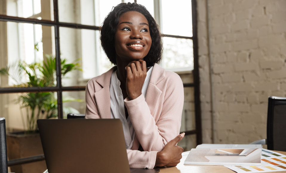 African American women smiling confidently in front of computer