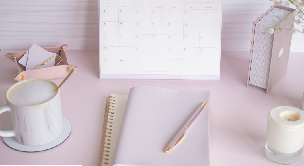 pink desk with pink pen, notebook and coffee